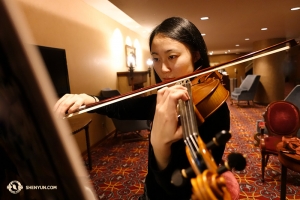 Skrzypaczka Karen Chen skupia się na przygotowaniu do występu. Artyści tacy jak Chen — w tym roku grała już na ponad 100 występach, a za sobą ma 11 sezonów z Shen Yun - zawsze dokładają starań w dalsze doskonalenie swoich umiejętności. (fot. Annie Li)