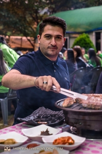 Następnie orkiestra przemieściła się do miasta Daegu, gdzie odbył się pierwszy koncert. Pierwszy skrzypek Stepan Khalatyan i reszta grupy delektują się tradycyjnymi koreańskimi potrawami z grilla, aby wprowadzić się w nastrój. (fot. TK Kuo)  
