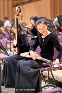 Grająca na pipie Miao-Tzu Chiu dostraja swój instrument uprzednim założeniu nowej struny.