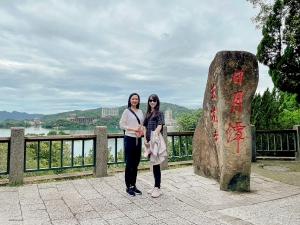 MC Nancy Zhang (z lewej) i Sopranistka Rachael Bastick pozują przy imponującej skale. Czy potrafisz odczytać lub odgadnąć trzy znaki napisane na froncie? (Podpowiedź: nazwa jeziora, ale po chińsku).